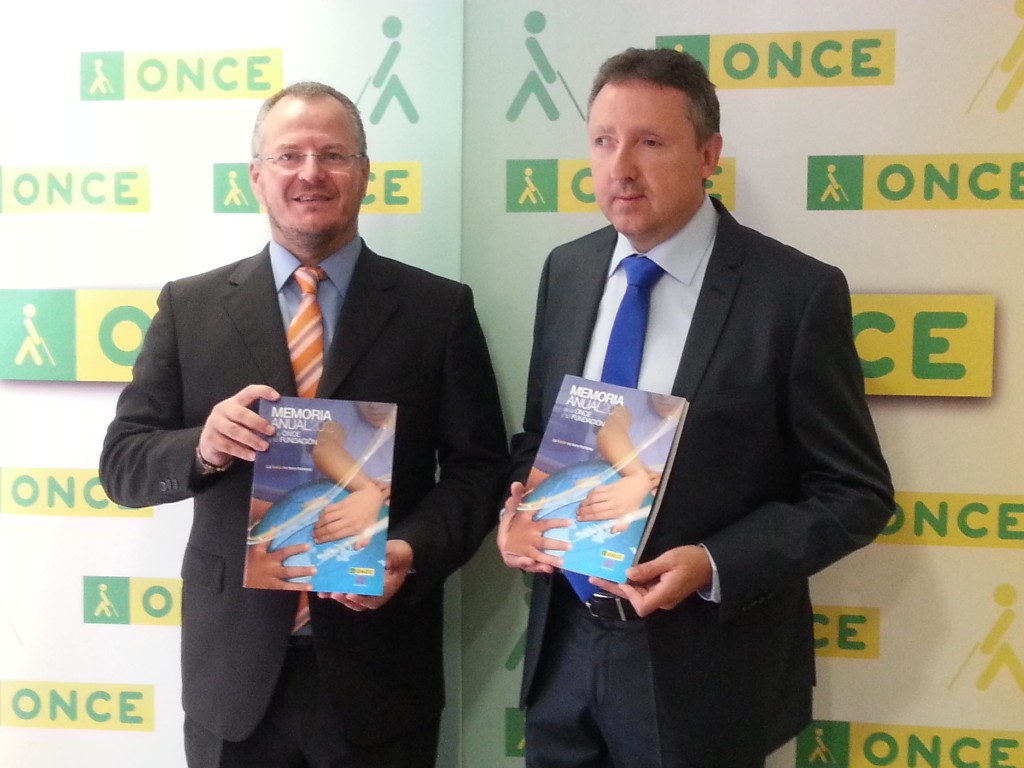 El delegado territorial de la ONCE en Andalucía, Ceuta y Melilla, Patricio Cárceles, junto al director de la ONCE Málaga, Cristóbal Martínez, enseñando el libro de la memoria