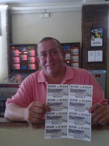 Plano medio del vendedor del 'Sueldazo' del domingo 18 de agosto enseñando algunos de los cupones que vende