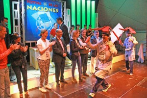 En la imagen, los premiados por el mejor disfraz recogen el trofeo. Los ganadores van disfrazados de inspectos con unas hélices sujetas a su cabeza. Tras ellos, las autoridades presentes en el acto aplauden y ríen durante la entrega