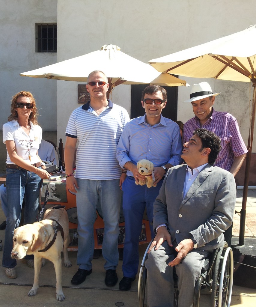 En la imagen, las autoridades presentes en el Día de la ONCE posan junto a la mesa informativa sobre los perros guía