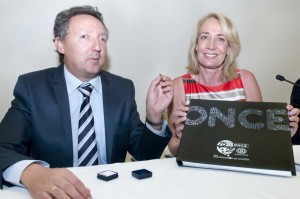 En la imagen, Cristóbal Martínez enseña el pin obsquiado por el Ayuntamiento de Benalmádena, mientras que la alcaldesa de la localidad muestra el lbro del 75 aniversario de la ONCE