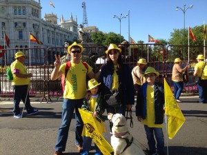 En la imagen, Francis posa junto a su marido, sus dos hijos y su perra guía, todos vestidos de amarillo, durante la marcha amarilla de la ONCE organizada en Madrid. En el fondo, se vislumbra la CIbeles
