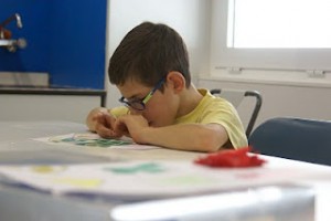 En la imagen, aparece un niño dibujando en un folio