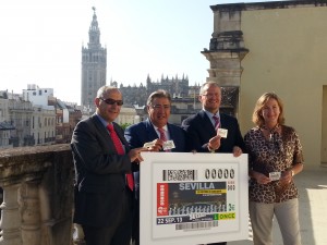 El subdelegado territorial de la ONCE en Andalucía, Ceuta y Melilla, Francisco Arroyo, el alcalde de Sevilla, Juan Ignacio Zoido, el delegado territorial de la ONCE en Andalucía, Ceuta y Melilla, Patricio Cárceles y  la delegada de Cultura, Educación, Deportes y Juventud del Ayuntamiento de Sevilla, María del Mar Sánchez, sostiene la imagen del cupón dedicado a la Carrera Nocturna. Lo hacen en la azotea del Ayuntamiento, con la Giralda de fondo