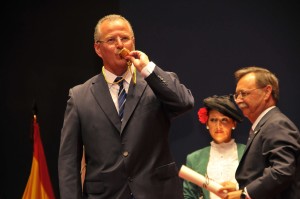 En la imagen, el delegado territorial de la ONCE en Andalucía, Ceuta y Melilla, Patricio Cárceles, besa la Medalla de la Autonomía, mirando al público