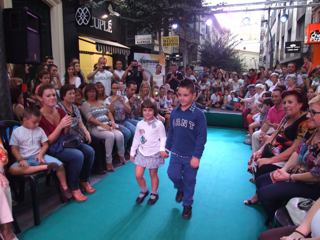 Dos pequeños de la ONCE desfilando ante la atenta mirada del público