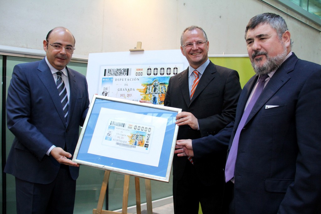 El presidente de la Diputación de Granada, Sebastián Pérez, el delegado territorial de Andalucía, Ceuta y Melilla, Patricio Cárceles, y el director de la ONCE en Granada, , muestran el cupón dedicado a la Diputación de Granada