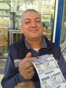 Juan Hernández posa con los cupones en su punto de venta habitual