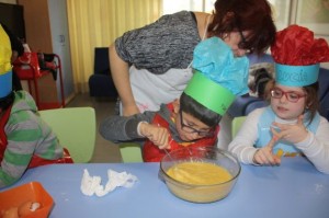 Uno de los chicos prepara la masa para las tortitas Uno de los chicos prepara la masa para las tortitas