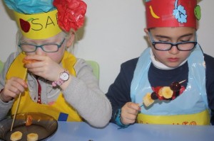 Las brochetas de frutas pusieron el toque de color y de vitaminas a las jornadas culinarias Dos niños preparan brochetas de frutas