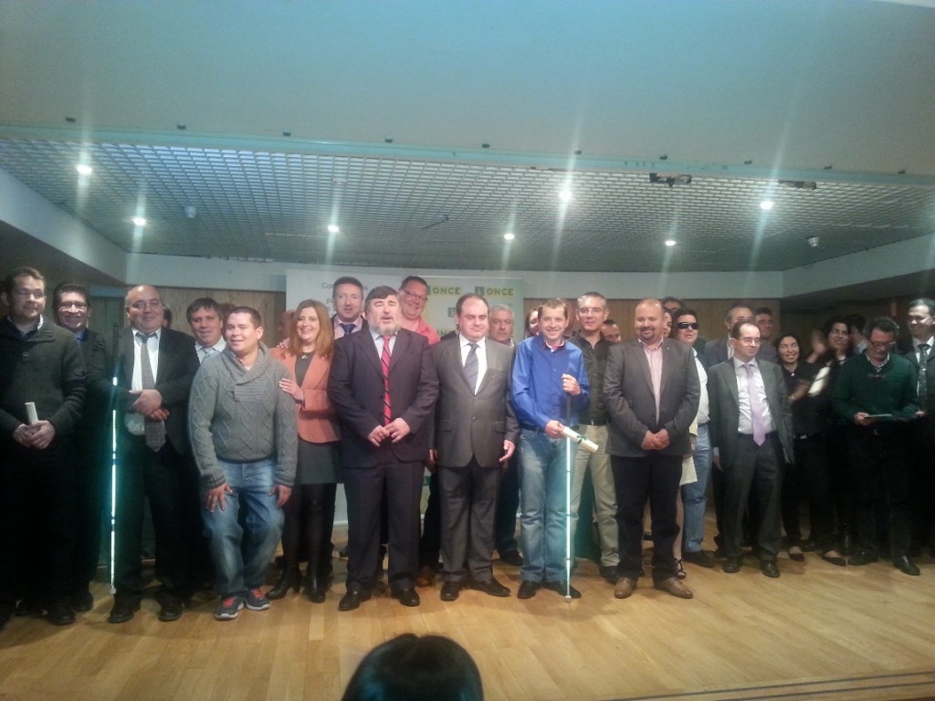 Foto de familia de los vendedores junto a los directores de la ONCE en Granada, Jaén y Almería en el escenario