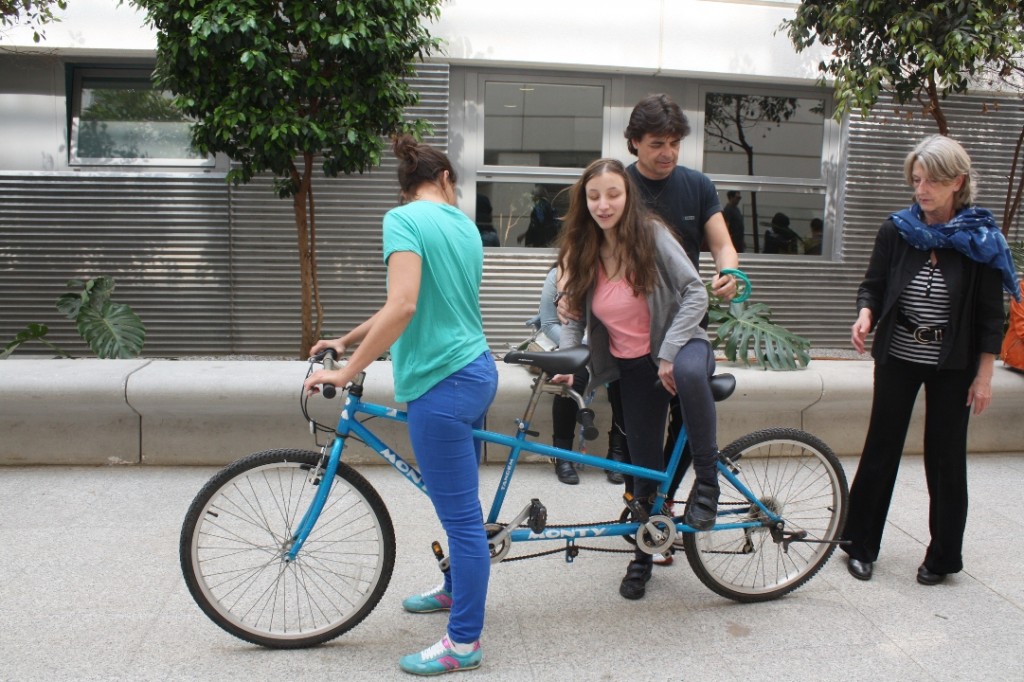 Dos chicas suben a una bicicleta de dos plazas dentro del patio de recreo del Centro de Recursos Educativos