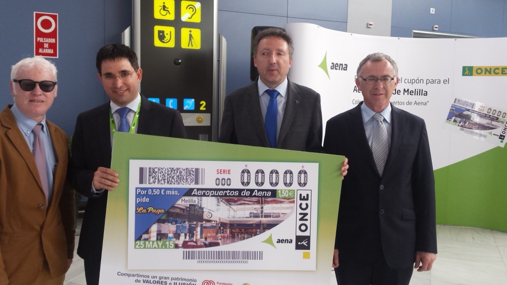 Cristóbal Martínez junto al director del Aeroopuerto de Melilla, Joaquín Rodríguez, el director de la ONCE en Málaga, José Miguel Luque, y el director de la ONCE en Melilla, Carlos Gordillo, tras la imagen del cupón