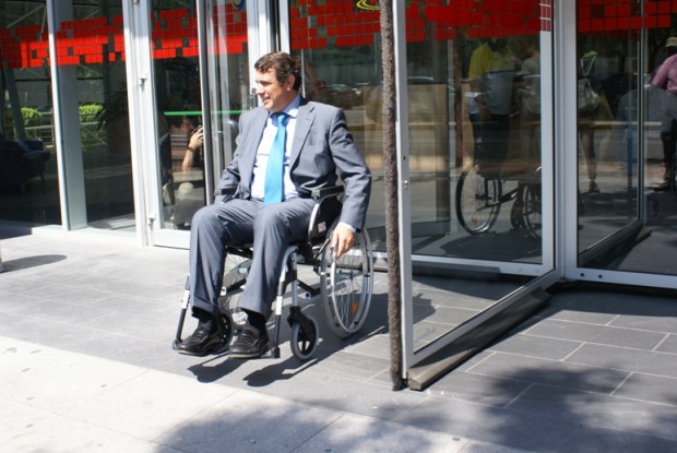 Uno de los empresarios participantes cruza la puerta giratoria del pabellón de Fundación ONCE en la Cartuja de Sevilla