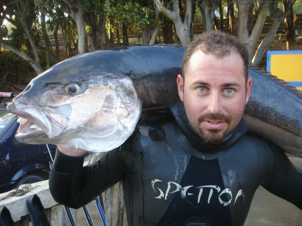 Manuel Martín con en primer plano sosteniendo una de sus capturas