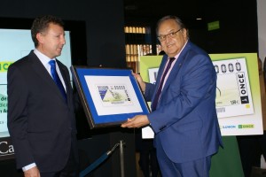 El delegado territorial de la ONCE en Andalucía, Ceuta y Melilla, Cristóbal Martínez, hace entrega del cupón del Centenario de la Federación Andaluza de Fútbol a su presidente, Eduardo Herrera