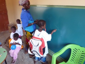 Una alumna en la pizarra junto a su profesora y otras compañeras