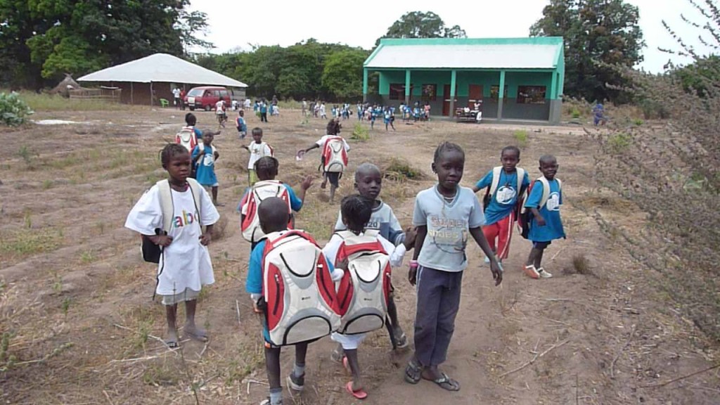 Una esplanada de tierra por donde transitan los niños que, con sus mochilas de la ONCE, van camino de la escuela