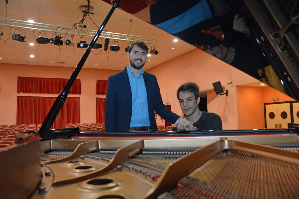 A la izquierda Álvaro Bernal, cantante clásico. A la derecha, Víctor Gómez, pianista. Ambos se muestran junto al piano en el Salón de Actos de la ONCE Andalucía.