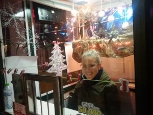 Rocío León, ganadora del I Concurso de decoración navideña de los kioskos de la ONCE aparece en su kiosko decorado con motivos navideños
