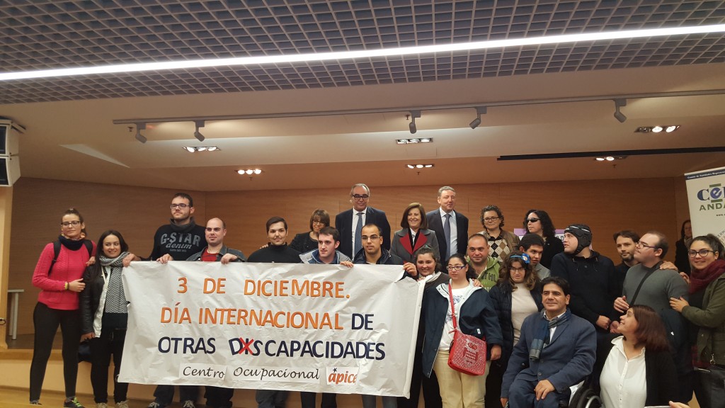 Foto familia en la presentación del cupón con motivo del Día Internacional de Personas con Discapacidad  sostienen un cartel con el lema 'Día Internacional de otras discapacidades' 