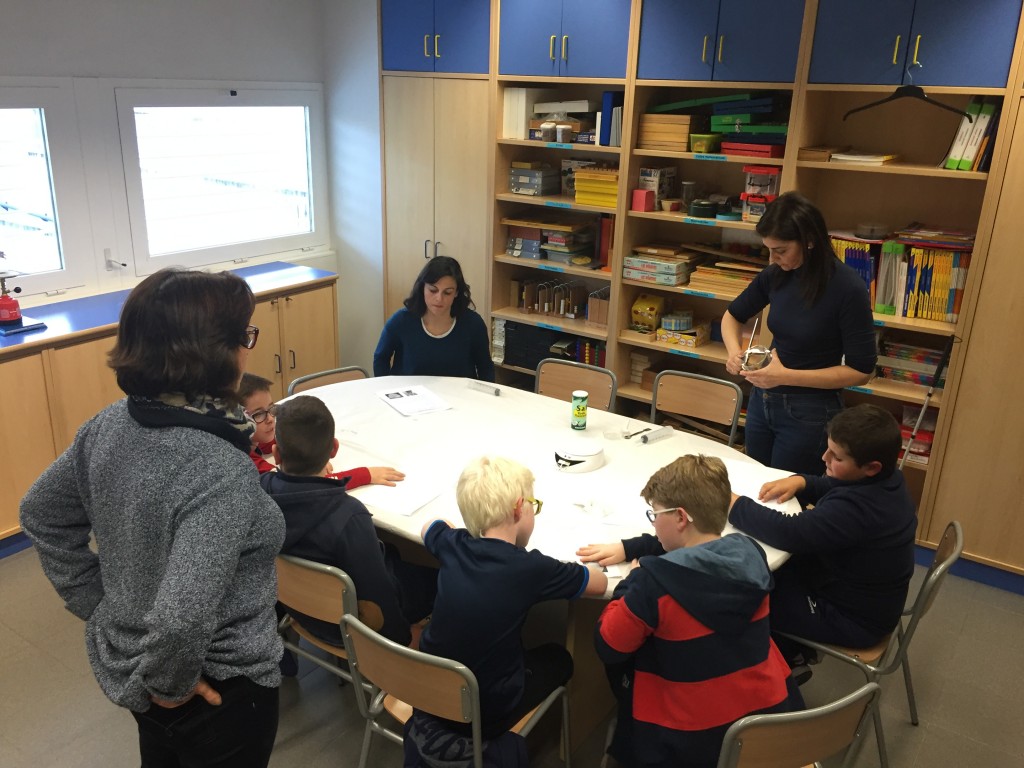 Alumnos en torno a una mesa atendiendo las explicaciones de la monitora