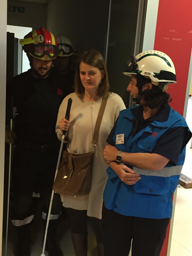 Colaboración de invidentes y especialistas de rescates en el simulacro. Salida de invidente junto a especialistas por una de las puertas de acceso