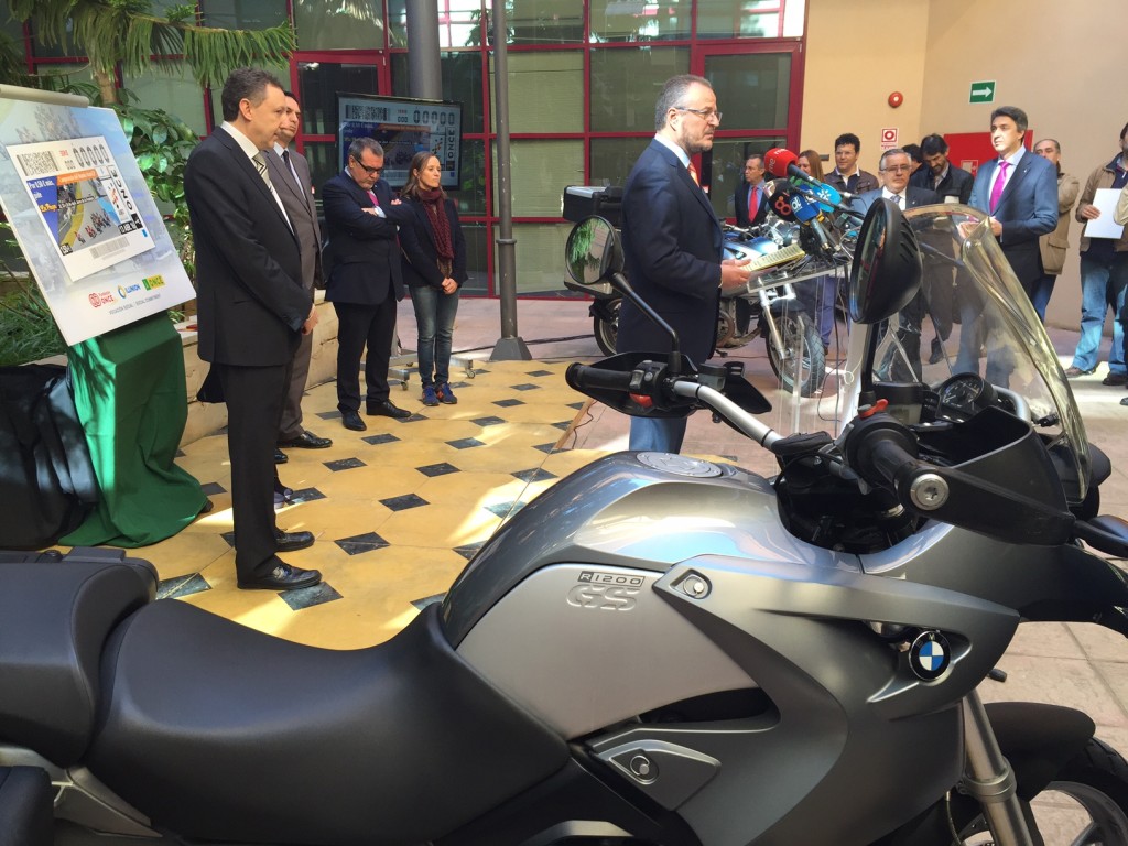 Vista lateral del momento de la presentación protagonizada por el director general adjunto de juego de la ONCE, Patricio Cárceles., con  una moto de primer plano en la imagen