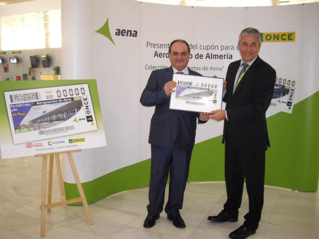 El director de la ONCE en Almería y el director del aeropuerto muestran el cupón a las cámaras