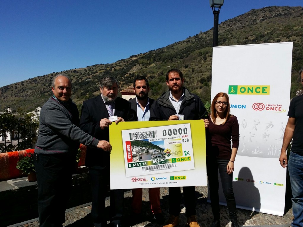 El director de la ONCE en Granada y el alcalde de Pampaneira con otras autoridades sosteniendo la imagen del cupón 