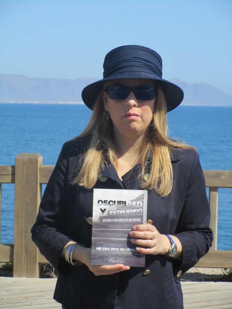 Helena Ríos posa con su libro con el mar de fondo