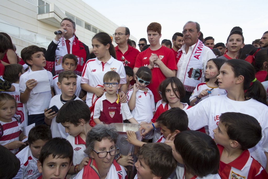 Niños de la ONCE se retratan junto a la copa en compañía de la directiva del Sevilla F.C y Cristóbal Martínez a los pies del escenario situado en el patio del CRE