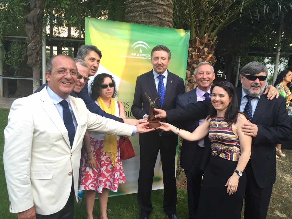 Foto de grupo con los representantes de la ONCE sonrientes sosteniendo la escultura