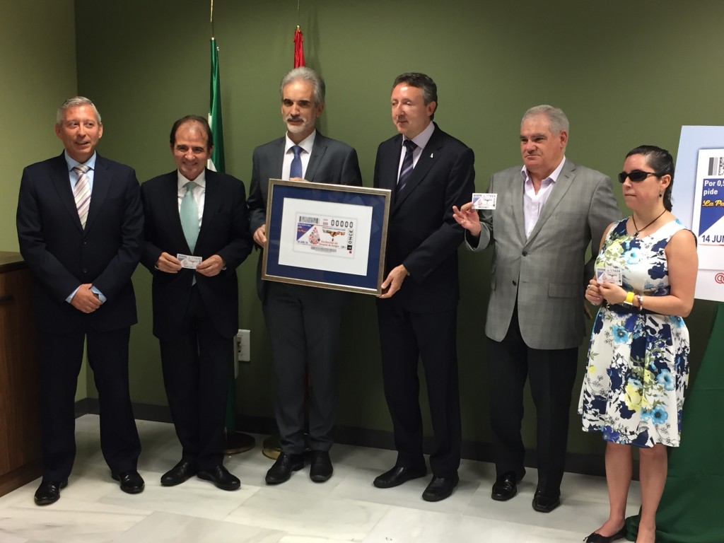 Foto de familia del consejero de Salud con el resto de autoridades y representantes de la ONCE en la sala en la que se presentó el cupón