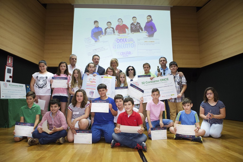Foto de familia del grupo todos enseñando a la cámara sus diplomas desde el escenario