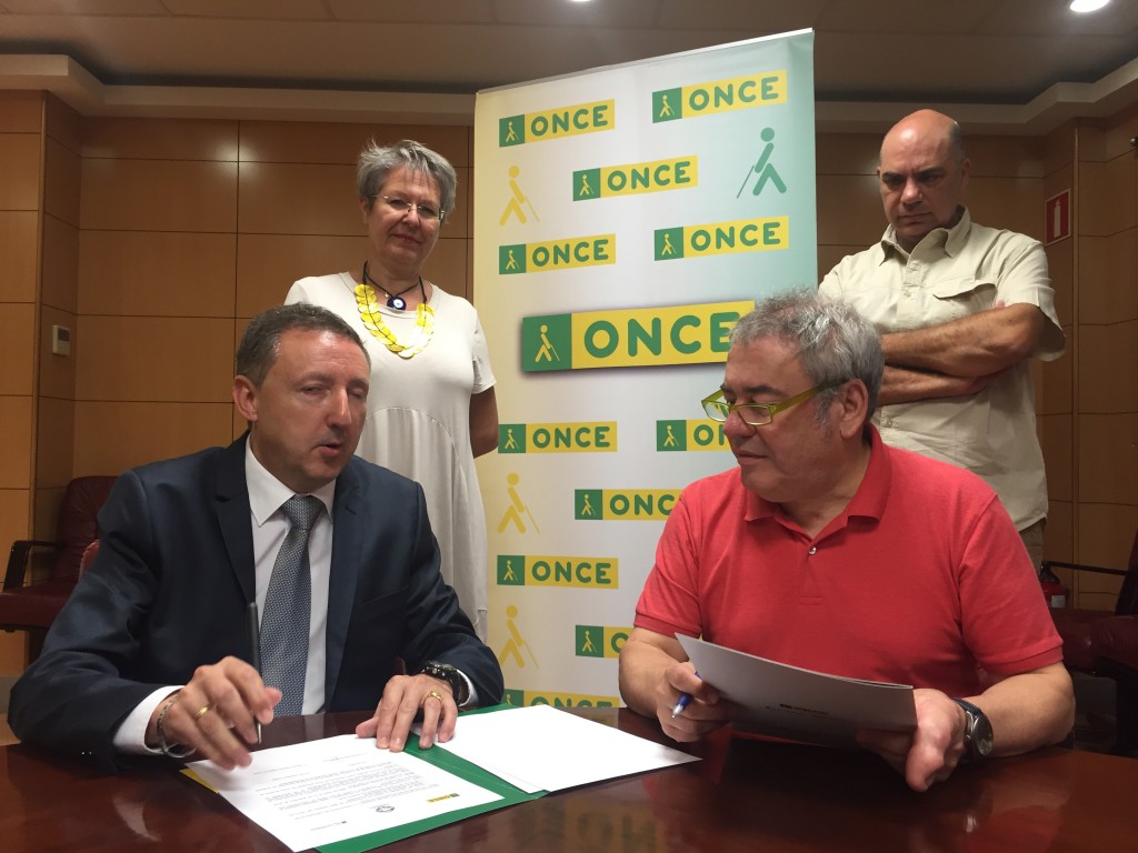 El delegado territorial de la ONCE y el coordinador de Iniciativa Ciudadana Sevilla en firmando las hojas del convenio