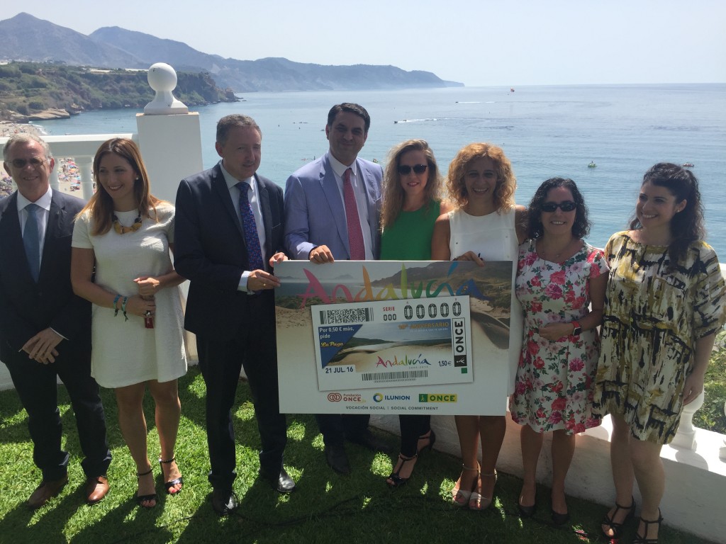 Foto de familia de los participantes sosteniendo el cupón con el Mediterráneo de fondo