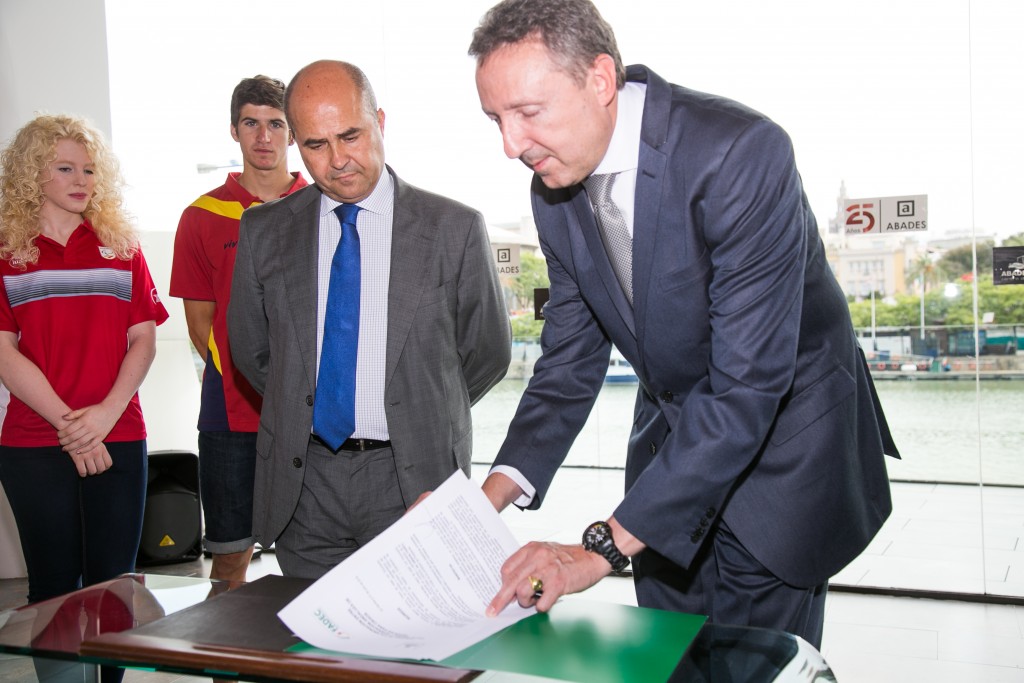 El delegado territorial de la ONCE y presidente de la FADEC firmando el convenio en presencia del director general adjunto del Grupo Abades