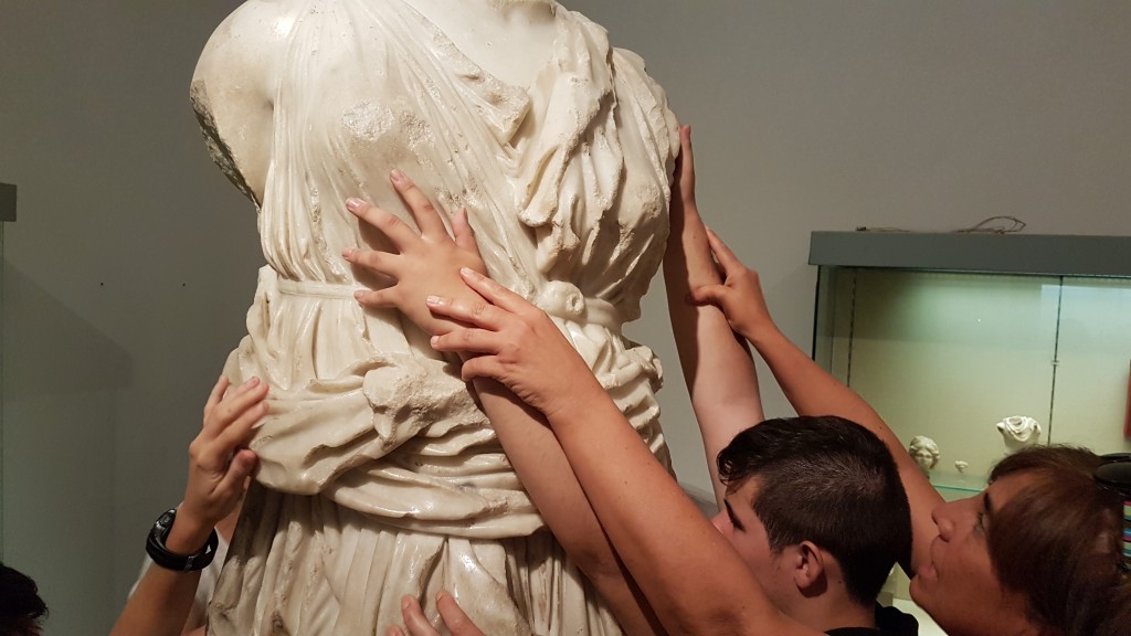 Los alumnos tocando el cuerpo de una escultura