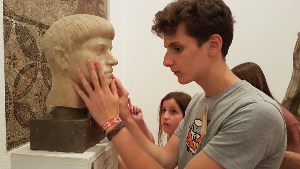 Un alumno tocando el rostro de una figura