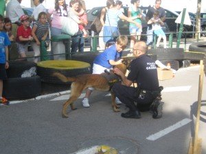 Un niño junto a un policía y uno de los perros policía