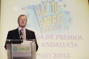 Primer plano de Patricio Cárceles en un momento de su intervención con el fondo del cartel del Concurso Escolar proyectado sobre el fondo