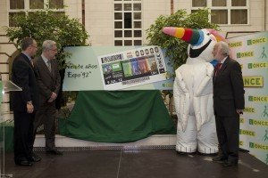 De izquierda a derecha, el delegado territorial, el consejero de Economía, el cartel del cupón, Curro y el presidente de Cartuja'93