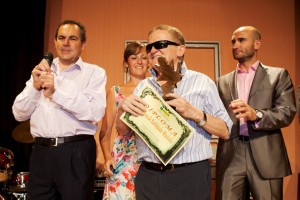 Imagen de uno de los finalistas posando con su diploma y placa