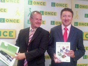 El delegado territorial con el director de la ONCE en Málaga mostrando un ejemplar de la Memoria