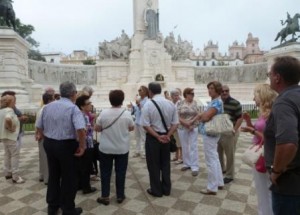 El grupo de trabajadores de la ONCE de Cádiz escuchan atentamente las explicaciones de una guía en la Plaza de España