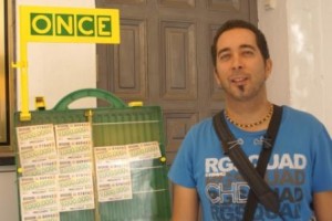 Francisco Pereira posa junto a su expositor portátil en su punto de venta habitual