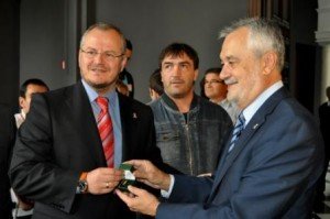 El presidente de la Junta, José Antonio Griñán, hace entrega de una insignia al delegado territorial de la ONCE en Andalucía, Ceuta y Melilla, Patricio Cárceles
